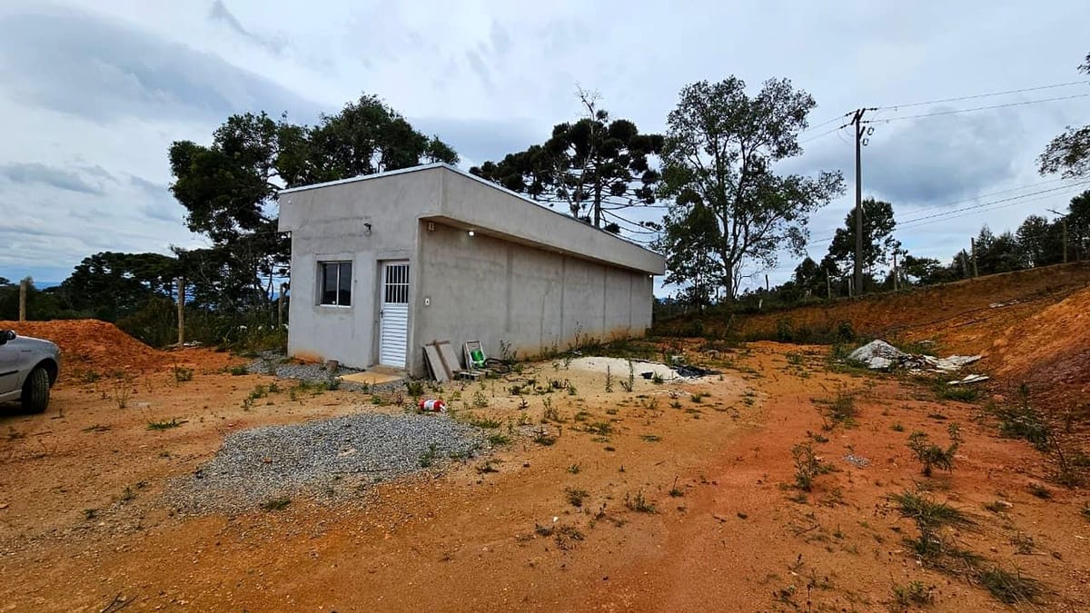 A casa construída vista do nível do solo, com acesso por estrada